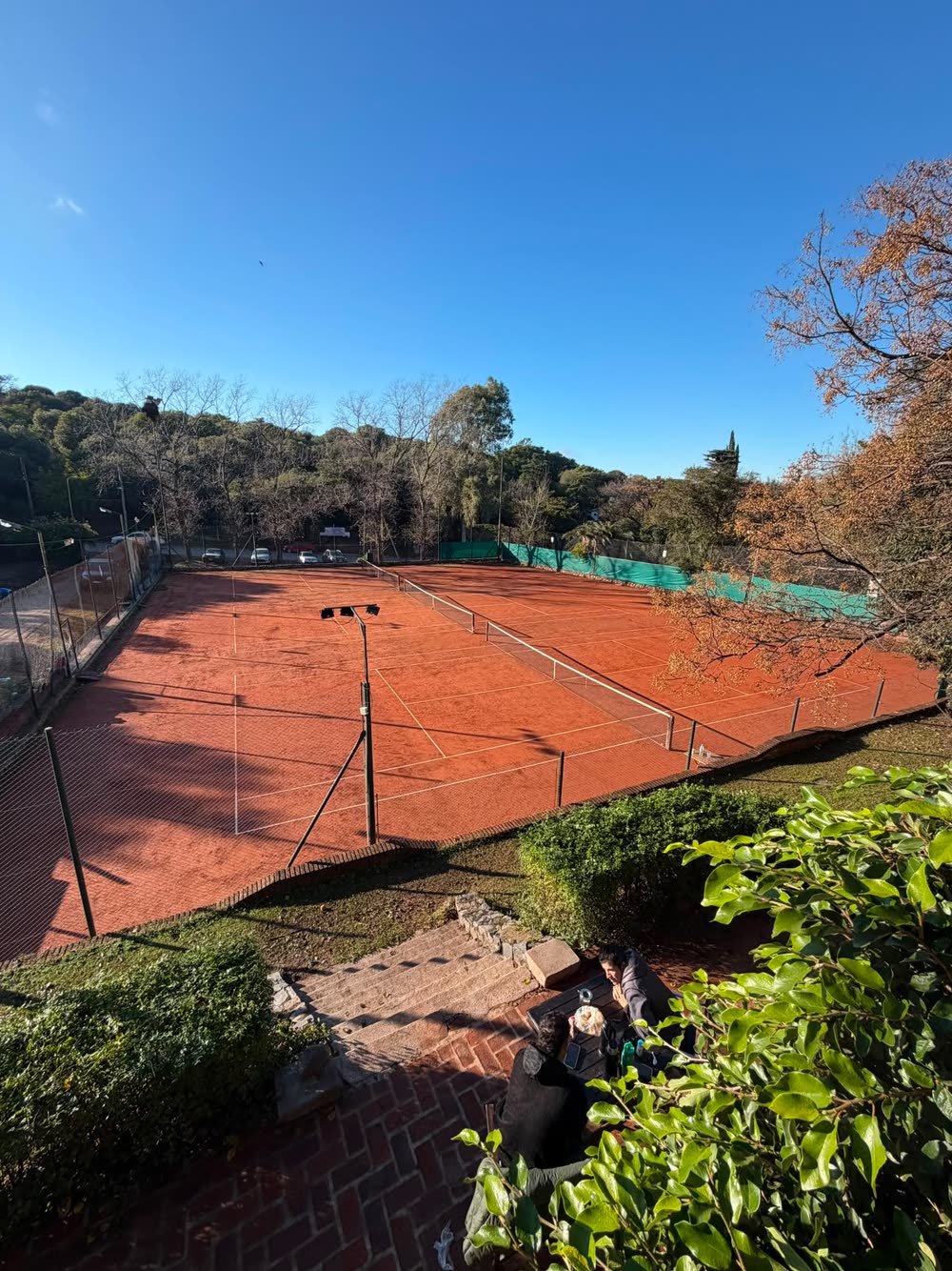 Vista de las canchas de polvo de ladrillo con las sierras de fondo